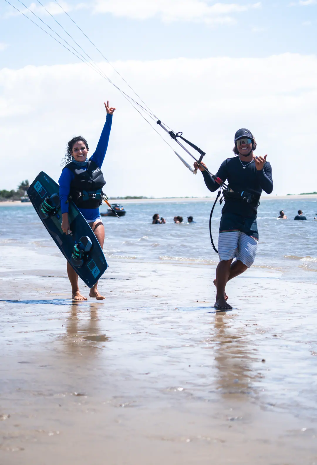 Aula de kite na água, com o instrutor ao lado da aluna