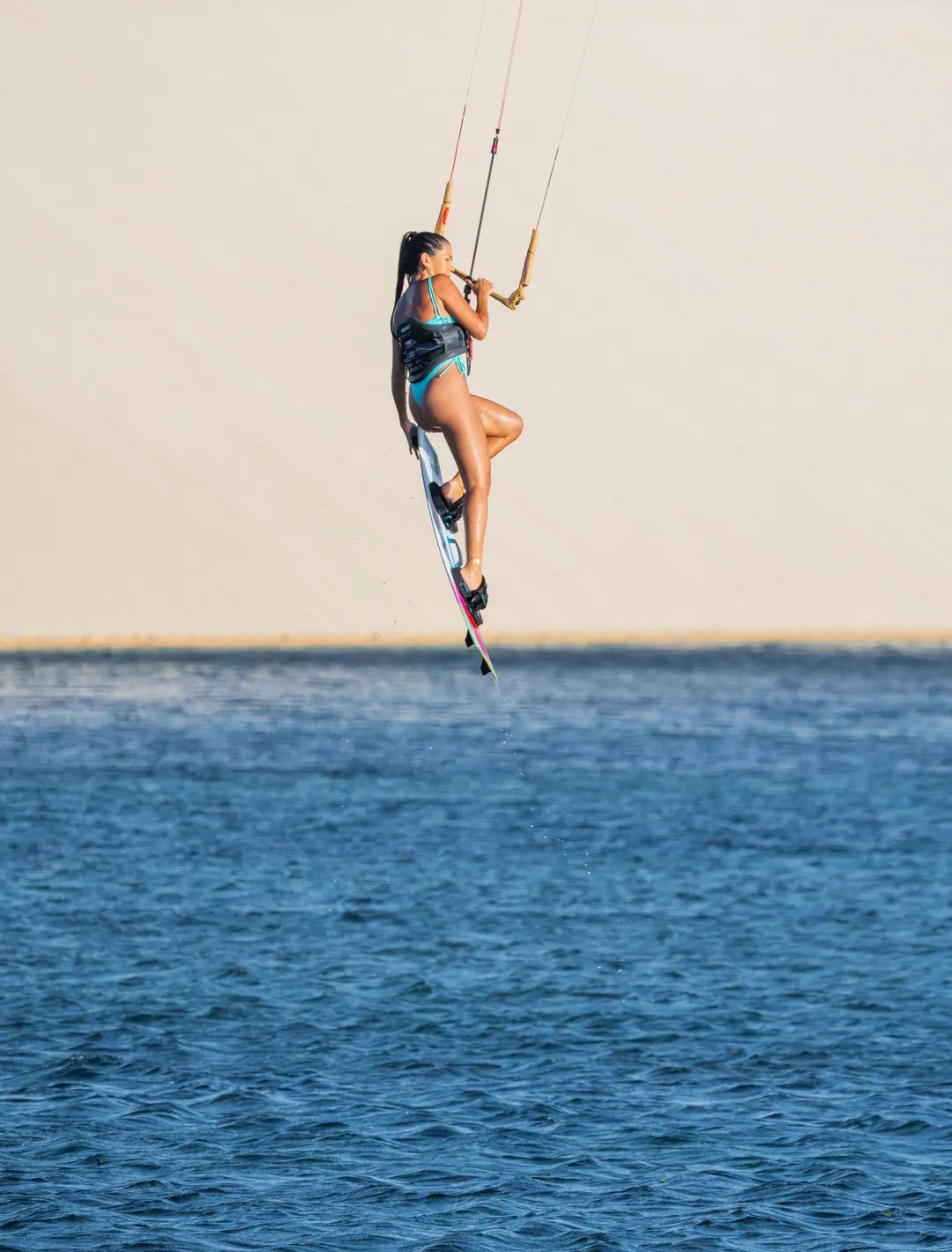 Eugênia num salto, com as dunas no horizonte