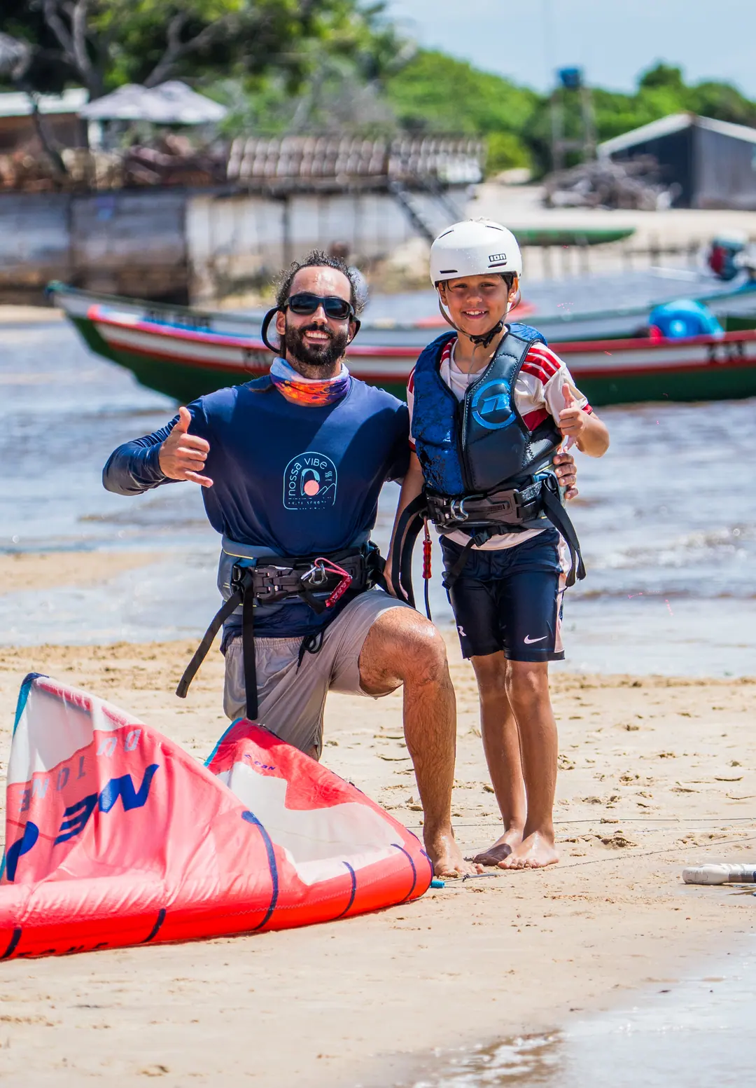 Duas pessoas na praia com o kite, depois da aula