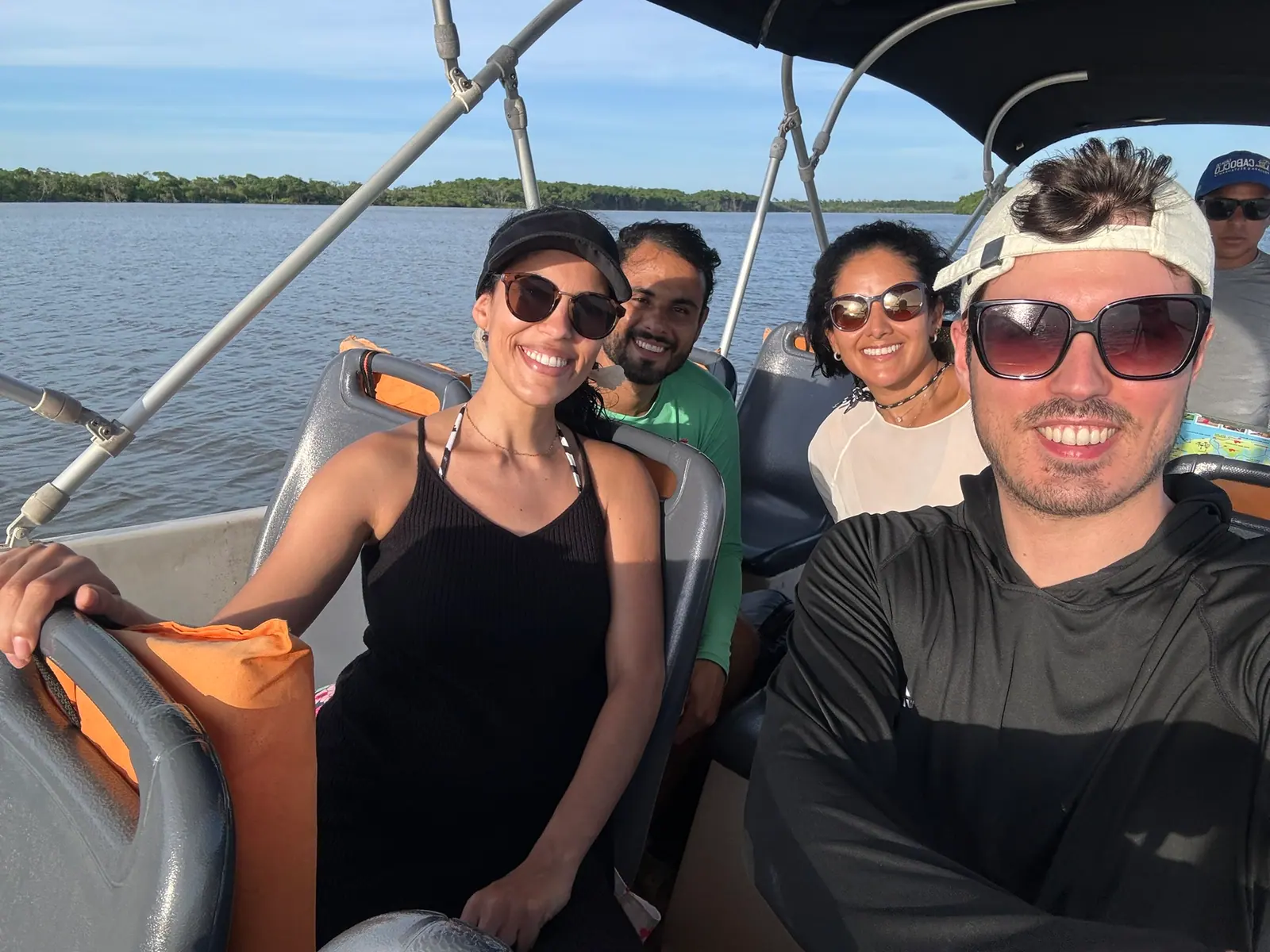 Turma sorrindo numa lancha, durante um passeio